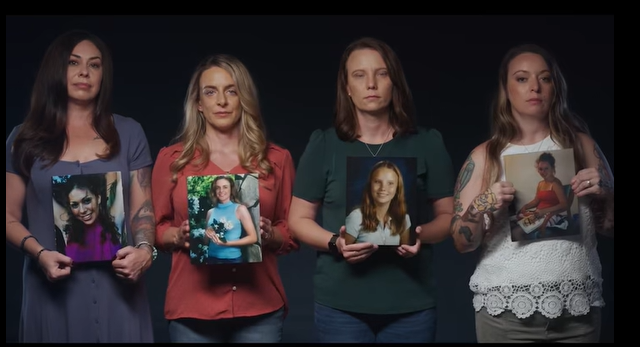 Four women stand together holding photos of them when they were younger, the age they were abused by Epstein